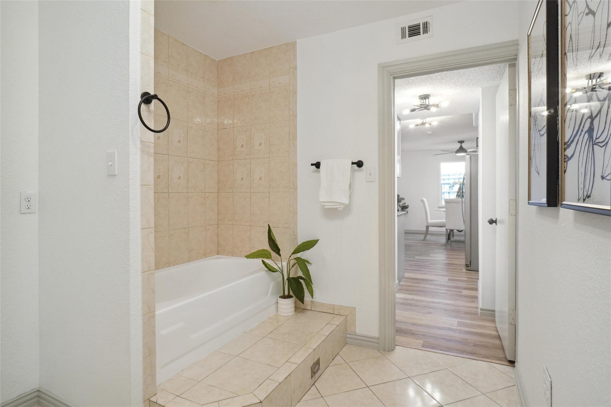 new bathroom remodel in Royse City by a general contractor featuring a newly installed spa tub, flooring, and wall fixtures.
